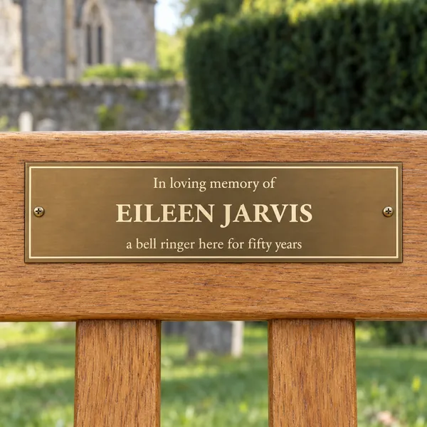 Personalised aged brass bench plaque 225 × 65 mm, shown with example wording